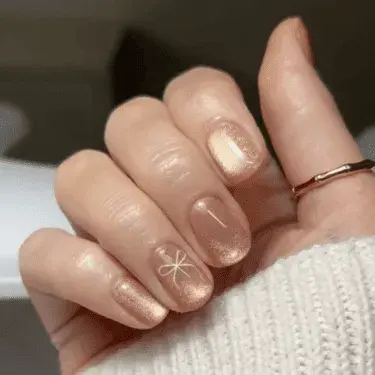 Manicure with gold polish and bow nail art