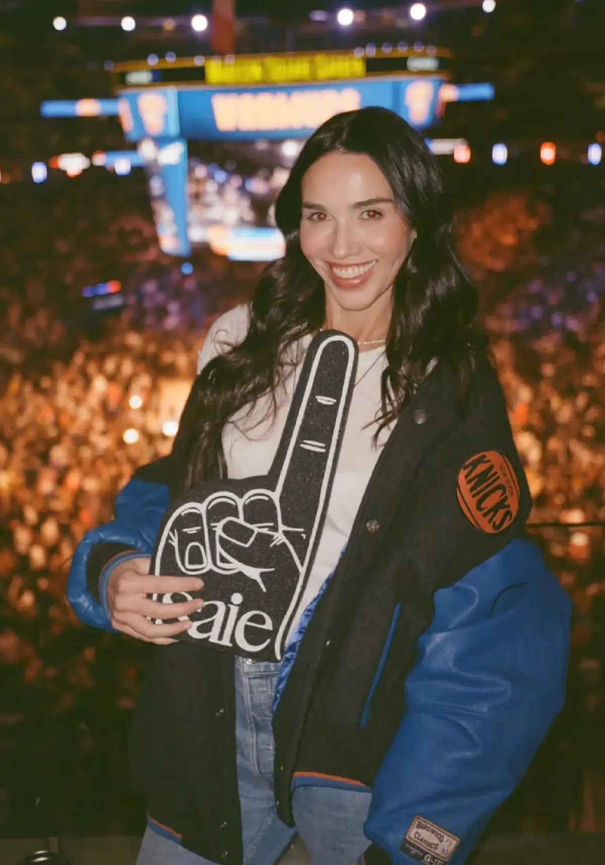 Saie founder Laney Crowell holds a Saie-branded foam finger at a New York Knicks game at Madison Square Garden.